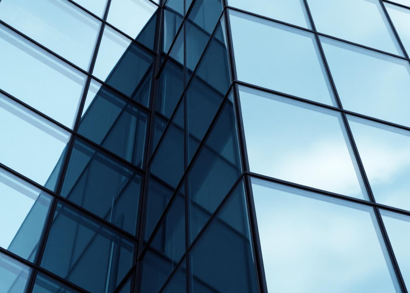 Close-up of modern glass and steel building facade reflecting the sky